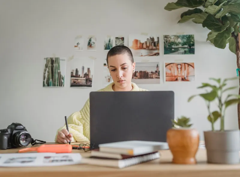 A freelance designer working at a laptop in her studio